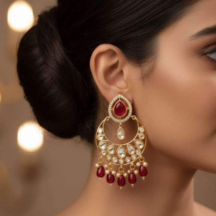 Close-up of a woman wearing red and gold earrings with a blurred background
